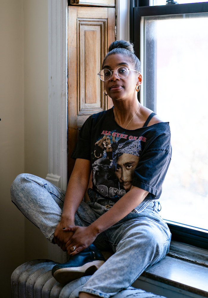 portrait of Simone White, sitting on a windowsill